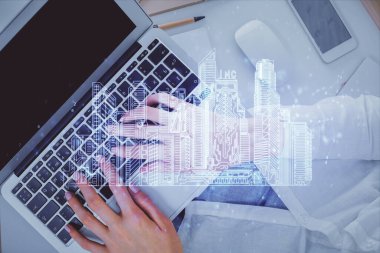 Double exposure of woman hands working on computer and buildings construction hologram drawing. Top View. smart city concept. clipart