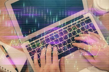 İnsan elinin bilgisayar klavyesinde ve forx grafik hologramının üzerinde yazarken çifte pozlama. Üst Manzara. Finans piyasası kavramı.