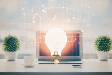 Bilgisayar ofisinde ampul simgesi hologramıyla birlikte. Çifte maruziyet. Fikir kavramı.