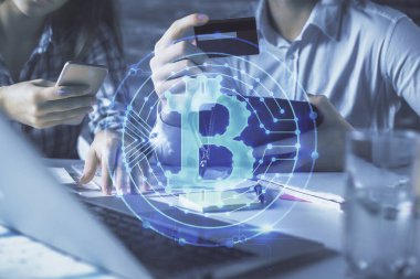 Bir kredi kartı ve kripto temalı hologram çizimi tutan kadın ve erkeğin online alışverişine iki kez maruz kalıyorlar. Engelleme zinciri ve E-ticaret çevrimiçi ücret kavramı.