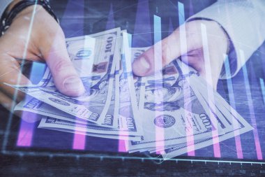 Finansal grafiğe çoklu pozlama hologram, Amerikan dolarları ve insan eli. Analiz kavramı.