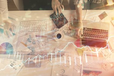 Birlikte çalışan kadın ve erkeğin birden fazla pozu ve finansal grafik hologramı. İş konsepti. Bilgisayar arkaplanı.