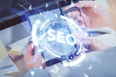 Dijital bir cihaz ve seo çizimi kullanan bir adamın el ele tutuşması. arama optimizasyonu kavramı.