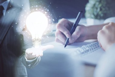 Arka planda not alan bir kadının eline ampul çizmek. Fikir kavramı. Çift pozlama