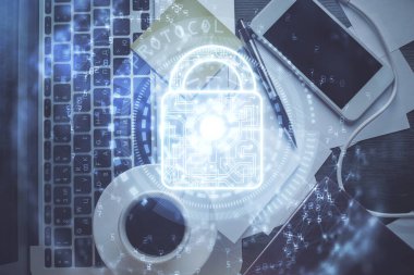 Bilgisayarla çalışma masası arkaplanının üzerine iki kat kilit hologramı çiziliyor. Veri güvenliği kavramı. Üst görünüm.