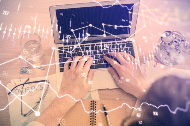 Dizüstü bilgisayarda klavye ve forx grafik hologram çizimlerini yazarken çift pozlama. Üst Manzara. Finans piyasası kavramı.