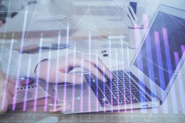Arka planda dizüstü bilgisayar üzerinde çalışan adam ile borsa grafiği çoklu pozlama. Finansal analiz kavramı.