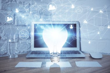 Bilgisayar ofisinde ampul simgesi hologramıyla birlikte. Çifte maruziyet. Fikir kavramı.