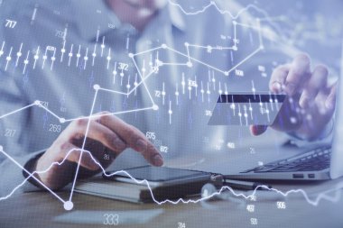 Ellerinde kredi kartı ve forex çizimi olan bir adamın çift pozu. İnternet E-ticaret kavramında hisse senedi ve dijital fintech.