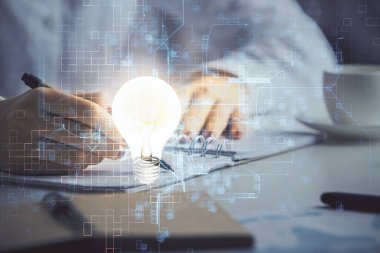 El üstünde tutulan ampul hologramı notlar alıyor. Fikir kavramı. Çift pozlama