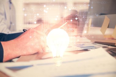 Dijital bir cihaz ve ampul hologram çizimi kullanarak insanın ellerini tutarken çift pozlama. Fikir kavramı.