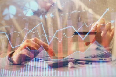 Ellerinde kredi kartı ve forex çizimi olan bir adamın çift pozu. İnternet E-ticaret kavramında hisse senedi ve dijital fintech.