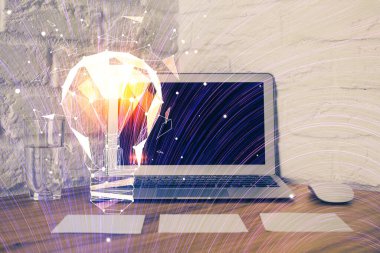 Bilgisayar ofisinde ampul simgesi hologramıyla birlikte. Çifte maruziyet. Fikir kavramı.