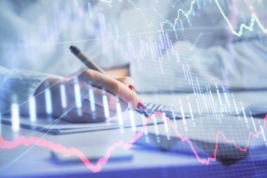 Forex grafik hologramı ile not lar yapan kadın ellerinin çift pozlama. Konsept borsa analizi.