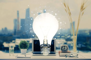 Bilgisayar ofisinde ampul simgesi hologramıyla birlikte. Çifte maruziyet. Fikir kavramı.