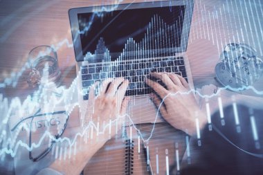 Dizüstü bilgisayarda klavye ve forx grafik hologram çizimlerini yazarken çift pozlama. Üst Manzara. Finans piyasası kavramı.
