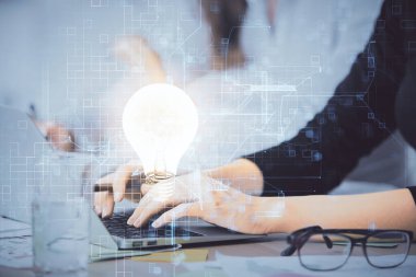 Bilgisayarda yazı yazan ve ampul çizen bir kadının ellerine iki kez maruz kalmış. Fikir kavramı.