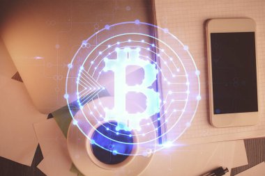 Telefonlu masanın üzerinde iki kat daha fazla engelleme temalı hologram görüntüsü var. Üst Manzara. Kripto teknolojisi kavramı.