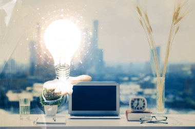 Bilgisayar ofisinde ampul simgesi hologramıyla birlikte. Çifte maruziyet. Fikir kavramı.