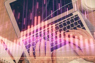 İnsan elinin bilgisayar klavyesinde ve forx grafik hologramının üzerinde yazarken çifte pozlama. Üst Manzara. Finans piyasası kavramı.