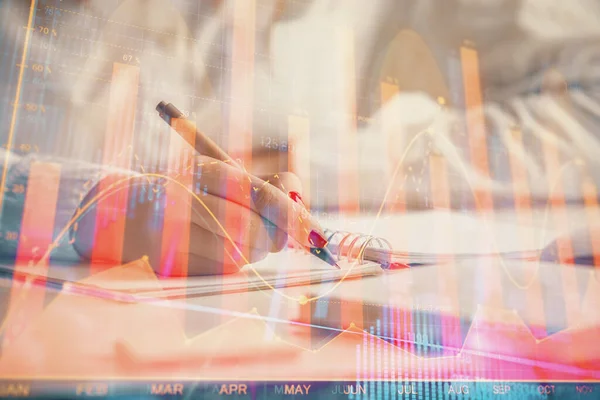 Double exposure of woman\'s hands making notes with forex graph hologram. Concept stock market analysis.