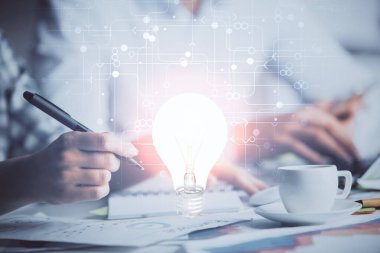 Arka planda not alan insanların üzerine çizim yapan ampullerin çifte pozu. Fikir kavramı