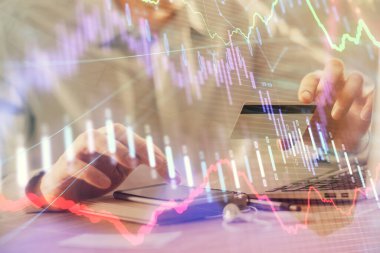 Ellerinde kredi kartı ve forex çizimi olan bir adamın çift pozu. İnternet E-ticaret kavramında hisse senedi ve dijital fintech.