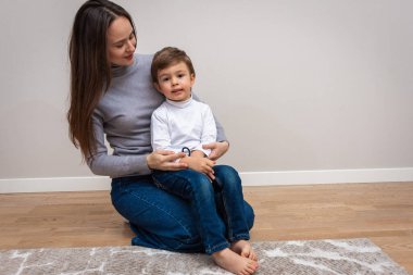 Hassas bir an. Bir anne, sevimli bebeğiyle harika vakit geçirmekten zevk alır. Onu kollarına alır ve nazikçe ona sarılır. Annelik kavramı ve mutlu çocukluk.