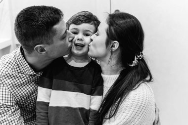 Genç ebeveynler oğullarına sarılırlar.