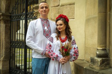 Birbirine aşık genç bir çift, eski şehir Lviv 'de geleneksel Ukrayna gömlekleriyle yürüyen bir aile. Gençler eski Lviv kasabasında sarılıyor