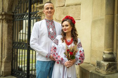 Birbirine aşık genç bir çift, eski şehir Lviv 'de geleneksel Ukrayna gömlekleriyle yürüyen bir aile. Gençler eski Lviv kasabasında sarılıyor