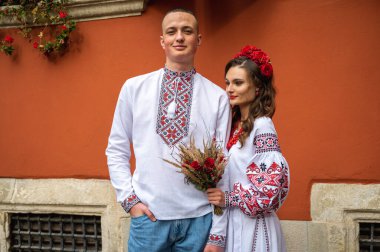 Birbirine aşık genç bir çift, eski şehir Lviv 'de geleneksel Ukrayna gömlekleriyle yürüyen bir aile. Gençler eski Lviv kasabasında sarılıyor