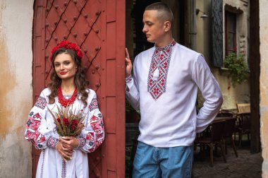 Aşık genç bir çift, Ukrayna 'nın eski şehri Lviv' de kırmızı-turuncu arka planda el ele tutuşan bir aile. Gençler eski Lviv kasabasında sarılıyor 