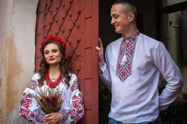 Aşık genç bir çift, Ukrayna 'nın eski şehri Lviv' de kırmızı-turuncu arka planda el ele tutuşan bir aile. Gençler eski Lviv kasabasında sarılıyor 