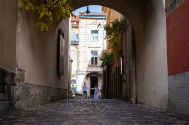 Aşık genç bir çift, Ukrayna 'nın işlemeli elbiseleriyle eski şehir Lviv' de yürüyen bir aile, el ele tutuşuyorlar. Gençler eski Lviv kasabasında sarılıyor