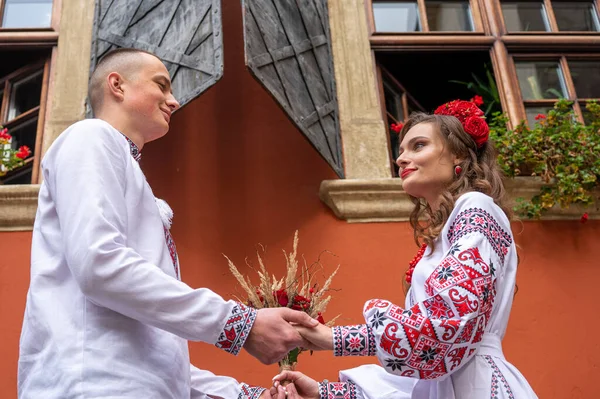 幸福的年轻夫妇恋爱了 一家人穿着传统的乌克兰衬衫 手挽手 手挽手 走在乌克兰古老的城市利沃夫 在利沃夫老城 年轻人拥抱在一起 — 图库照片