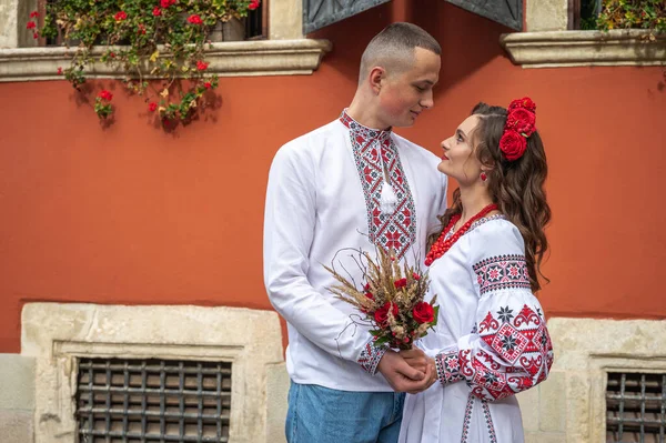 愛の幸せな若いカップル 伝統的なウクライナのシャツで旧市街のリヴィウを歩く家族 若い人たちは旧市街で抱擁します — ストック写真