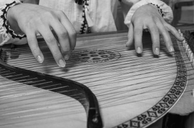 black and white classic photo, learning music, young girl plays ukrainian folk instrument, bandura, hands and strings close up