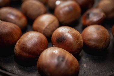 Roasted chestnuts on a dark surface background. Close up view