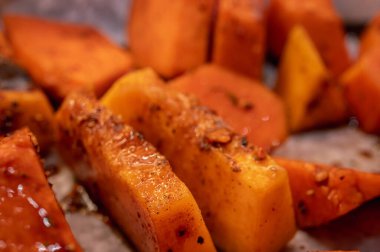 Roasted pumpkin on a light parchment background. Close up view, selective focus. Healthy food