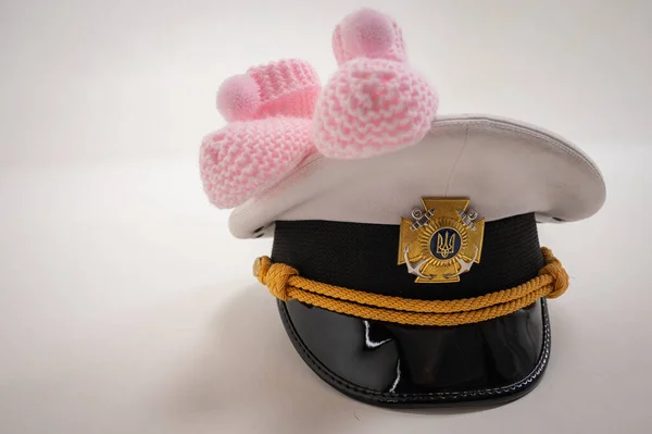 Ukrainian military cap and children\'s shoes. Waiting for the birth of a child, the father is in the military