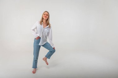 Sportif enerjik aktif genç kız bir bacağının üzerinde duruyor ve bir işaret üzerinde meditasyon yapıyor, rahatlıyor, dinleniyor. Yazma yeri olan hafif arkaplan