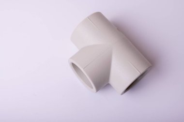 light PVC pipe tee connection for water isolated on light background close up.
