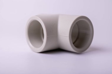light PVC pipe tee connection for water isolated on light background close up.
