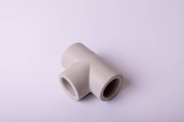 light PVC pipe tee connection for water isolated on light background close up.