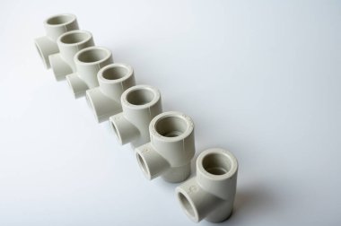 Açık gri PVC boru çubukları su için, çeşitli tiplerde ve çaplarda, yakın plan ışık altında izole edilmiş. yan görünüm, üst görünüm