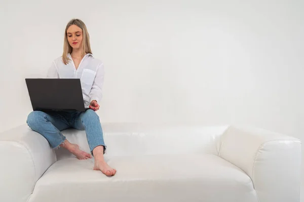 Młoda Ładna Dziewczyna Siedzi Laptopie Siedzi Kanapie Odizolowany Jasnym Tle — Zdjęcie stockowe