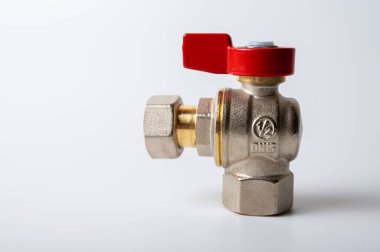 Pirinç rengi metal musluk, kırmızı kapakçık, farklı açı, arka planda izole, yakın plan, tesisat bağlantısı.