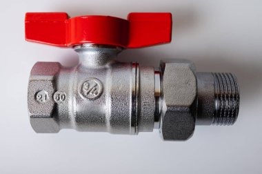 Pirinç rengi metal musluk, kırmızı kapakçık, farklı açı, arka planda izole, yakın plan, tesisat bağlantısı.