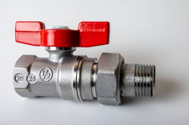 Pirinç rengi metal musluk, kırmızı kapakçık, farklı açı, arka planda izole, yakın plan, tesisat bağlantısı.